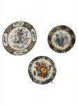 Lote c/ 3 pratos decorativos de porcelana estilo oriental, tamanhos e designs variados: Dama e Grou/Cegonha, Pavão e Peônias, e Arranjo Floral e Borboletas. Marcas do tempo. -dim- maior 15d / menor 11d