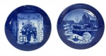 Lote com 2 Pratos de Natal Royal Copenhagen, anos 1999 (The Sleigh Ride) e 2000 (Trimming The Tree), em porcelana azul sob esmalte. Peças da aclamada série anual dinamarquesa, ideais para colecionadores de porcelana e itens comemorativos do Milênio. M