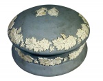 Caixa redonda em cerâmica Jasperware, cor azul-claro com relevo branco de figuras clássicas e videiras. Estilo Wedgwood, provável produção do século XX. Marcas do tempo. -dim- 16d 8a