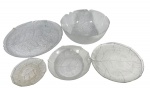 Parte de Conjunto de serviçoformaro por  5 grandes peças de mesa em vidro prensado transparente com textura e formato de folhas, composto por travessas e tigelas de tamanhos variados. Marcas do tempo. -dim- menor 15d/ maior plano 33d 2a.