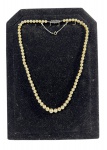 Lote de Colar Vintage de Pérolas (possivelmente simuladas/de concha) de uma volta, em tom creme, com fecho ornamentado em metal prateado com strass e corrente de segurança (pega-ladrão). Marcas do tempo. -dim- 50c.