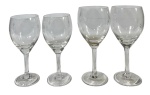 Lote com 4 taças em cristal incolor com pé, apresentando lapidação fina de folhagens/videiras no bojo. Marcas do tempo. -dim- menor 6d 14a/ maior 6d 16a.