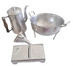 Lote contendo 4 utensílios vintage produzidos em alumínio para cozinha. Sendo 1 bule com alça de madeira e bico curvado, 1 funil, 1 escorredor redondo com 3 pés e alças rebitadas, sendo que necessita reparo e 1 fatiador de alimentos com 3 tipos de lâmina.