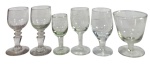Lote de 6 Cálices/Taças Antigas de Vidro/Cristal, Haste Curta, para licor ou vinho do Porto, apresentando variações de bojo, detalhes canelados e um exemplar com gravação em ácido (floral). Marcas do tempo. -dim- menor 3d 7,5a maior 6,5d 8a
