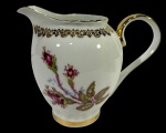 Leiteira da antiga Porcelana S. Itaqui - Paraná, decorado com flores roxas e detalhes dourados em relevo, incluindo a tampa. -dim- 12x7x10