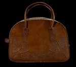 Bolsa produzida em couro artesanal vintage (possivelmente mexicana), estilo bowling bag, com repujado floral/cincelado e alças duplas; peça com patina natural e zíper metálico aparente. Marcas do tempo. -dim- 36x23