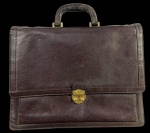 Pasta executiva ou maleta vintage em couro marrom/bordô com textura granulada e monograma discreto em relevo no corpo; fecho frontal dourado e interior multicompartimentado forrado com tecido monogramado. Marcas do tempo. -dim- 40x33x5