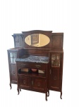 Graciosa cristaleira transição do estilo art decor a estilo art nouvex. Com duas colunas laterais com vidros bisotê. Apresenta na parte central compartimentos com chave e nicho para guarda provavelmente de bebidas, acima do nicho duas gavetas frontais com puxadores em bronze. Apresenta entalhes no centro das duas colunas e a parte central, encimados por antigo mármore rajado na cor preta com detalhes cinzas e brancos de origem europeia e fechando esse gracioso conjunto rico espelho bisotê. As colunas apresentam prateleiras em espelho e cristal. marcas do tempo - dim - 1,50x60x1,80 Espelho - 76x37