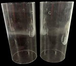 Lote de 2 (duas) peças cilíndricas produzidas em vidro transparente para iluminação, com furos de fixação na parte superior. Muito provavelmente globos ou chaminés de vidro para iluminação, como lustres, arandelas ou castiçais. Marcas do tempo. -dim- 12d x 23a