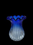 Vaso em cristal "estilo Murano", com a base na cor azul claro e o bico em azul royal. A peça apresenta corpo plissado e bico com borda ondulada, popularmente conhecida como "bico de pato". Marcas do tempo. -dim- 20d x 27a