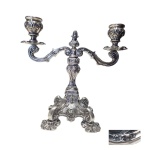 PRATA - Castiçal, contfrastado Águia 833 para 2 velas, lavrado e repuxado apoiado por haste sustentado por 4 pernas  recurvas, 1081g. 22 x 23 cm.