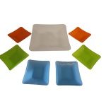 Sete travessas em vidro, a principal na cor branca, 32,5 x 32, 5 e as 6 menores, coloridas, 15 x 15  cm.