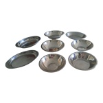 Baixela em inox composta de 8 travessas  4 circulares e 4 ovais, 30 x 20 a 26 x 20 cm. Diam. 24 a 22 cm.