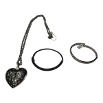 Um cordão com pedantife representando coração em metal prateado e 2 pulseiras, a preta está com o fecho quebrado.