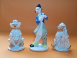 Lote de 3 palhaços em porcelana, sendo: Antiga escultura de palhaço em porcelana italiana, policromada, 20 X 8,5 cm - Antigo conjunto de 2 estatuetas de palhaços músicos, em porcelana com acabamento perolado/iridescente, casa um com 13 cm 