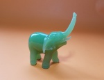 Bonito elefante em pasta de vidro verde, apresenta perda da presa esquerda - Dimensão: 7 X 3 cm - Altura: 8 cm