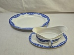Jogo de molheira e travessa oval rasa em porcelana Villeroy & Boch azul e branca. Medindo a travessa 34cm x 24,5cm e a molheira 19cm x 8,5cm de boca x 10,5cm de altura.