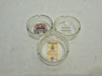 Lote de 3 cinzeiros redondos em vidro estampado com propagandas. Medindo 8cm x 3,5cm de altura.