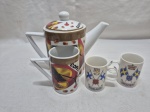 Lote de bule de café com 3 canecas diversas em porcelana. Medindo o bule 12cm de altura.