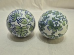 Par de bolas decorativas em porcelana pintada. Medindo 8cm de diâmetro.