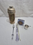 Lote diverso, composto de coqueteleira em metal, descansos de copo em plástico, etc. Medindo a coquiteleira 23cm de altura.
