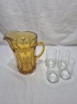 Lote de jarra em vidro âmbar e 4 copos em cristal incolor. Medindo a jarra 22m de altura.