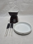 Lote de rechaud e petisqueira redonda em porcelana com 4 garfos de fondue em inox. Medindo a petisqueira 16cm x 3cm de altura.