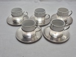Jogo de 5 xícaras de café em porcelana variada com suporte e pires em prata 90. Medindo 5cm x 5cm de altura.