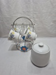 Suporte em metal com 4 xícaras de chá sem pires e açucareiro em porcelana. Medindo o suporte 26cm de altura.