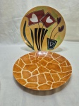 Lote de 2 pratos decorativos em porcelana pintada. Medindo o maior 27cm de diâmetro.