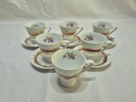 Jogo de 6 xícaras de café com 5 pires em porcelana Schmidt floral com friso ouro. Medindo 6,5cm x 6,5cm de altura. Peça com leves desgaste no friso.