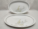Jogo de 2 travessas ovais rasas em porcelana Real com pintura de folhas e friso ouro. Medindo a maior 37cm x 22cm.