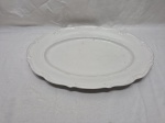 Travessa oval em porcelana branca com relevo na borda. Medindo 44cm x 30cm.