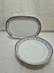 Jogo de travessa oval e travessa redonda em porcelana Germer com barra azul floral. Medindo 22,5cm x 5cm de altura; 29,5cm x 19,5cm.
