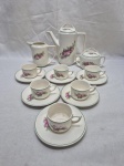 Jogo de servir café com 9 peças em porcelana Porto Ferreira flor rosa. Medindo o bule 14,5cm de altura, açucareiro com pequenos bicados.