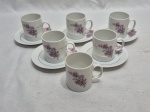 Jogo de 6 xícaras de café com 5 pires em porcelna Renner Medaillon flor roxa e friso ouro. Medindo 5cm x 5,5cm de altura.