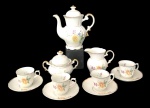 Serviço de café em porcelana Real S. Pablo, composto por bule, leiteira, açucareiro com tampa e 4 xícaras com pires. Decoração floral policromada com detalhes em dourado. Medida do maior 17cm x 16cm.