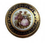 LIMOGES FRANÇA - Porta pílulas em pasta de porcelana francesa Limoges, decorada com cena galante ao estilo rococó e bordas em azul cobalto com detalhes dourados. Peça de fino acabamento, típica dos objetos de arte franceses produzidos para toucador ou coleção. Discreto bicado na tampa. Mede 5 cm.