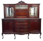 FELIPE SOARES & CAMPOS - Antiga Cristaleira em madeira nobre acastanhada, estilo Luís XV, com belíssimo trabalho de marcenaria e ferragens originais. Parte superior com portas de cristal lapidado e florais gravados, prateleiras internas espelhadas e vitrine central. Base com gavetas curvas, puxadores em metal trabalhado e laterais com portas emolduradas. Peça fabricada pela marcenaria Nossa Senhora da Penha  Felipe Soares & Campos Ltda., Rio de Janeiro, conforme etiquetas originais no verso. Um exemplar de elegância e tradição do mobiliário brasileiro do inicio do século XX. Divide-se em duas partes, a superior é móvel. Mede 1,96 cm comprimento x 60 cm largura x 1,86 cm altura.