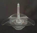 Centro de mesa formato cesta em cristal soprado translucido, desenho fluido e alça integrada. Peça leve, orgânica e elegante para composição de interiores. Mede 21 cm.
