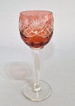BOHEMIA - Taça em cristal overlay vermelho alaranjado, bojo com profusa lapidação. Haste facetada. Med. 21 cm