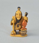 JAPÃO, Séc.XIX - Antigo Netzuke em Marfim com policromia, representando vendedor de peixe.  Assinado. Med. 5 cm.