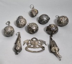 Antiga penca baiana de balangandãs em metal com 9 pingentes. Brasil, Séc.XIX/XX.. Med. 25 x 25 cm.