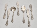 Conjunto com 7 talheres metal prateado, sendo 4 faças, 1 concha para doce e 1 colher. Sem marcas visíveis. Desgastes. Med 18 cm