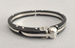 Pulseira americana tipo algema, feita em aço e detalhes em esmalte negro. marcas de uso. Medida interna: 6.5 cm   ------ https://www.walmart.com/ip/Two-Tone-Steel-Handcuff-Bangle-Bracelet-Secret-Shades/162600291?wmlspartner=wlpa&selectedSellerId=1233