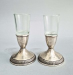 Par de pequenos castiçais em Prata de lei Sterling ( 925) com recipientes em vidro. Possui enchimento. Medida total: 14.5 cm. Peso bruto sem vidro: 382 gramas.