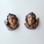 Par de querubins barrocos em madeira entalhada e policromada, trabalho português do século XIX. Modelados em madeira maciça, apresentam fisionomias delicadas, cabelos ondulados e asas em volutas, seguindo a tradição escultórica barroca de influência setecentista em Portugal. A policromia original, com craquelê antigo e vestígios de douração, revela pátina autêntica e desgaste natural do tempo. Verso plano, próprio para aplicação em oratórios ou altares domésticos, atualmente adaptados com suporte para fixação em parede. Conjunto harmonioso e raro de se encontrar em par, preservando caráter devocional e excelente presença decorativa. Dimensões: 20x20 centímetros.