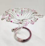 Elegante floreira italiana em vidro artístico Murano, modelada à mão em forma orgânica com bordas onduladas e movimento fluido, sustentada por base em espiral de grande efeito escultórico. O vidro cristalino recebe aplicações internas em tom fúcsia com delicados respingos e veios distribuídos ao longo de toda a peça, conferindo dinamismo e leveza visual. Trabalho típico das furnaces de Murano da segunda metade do século XX, combinando técnica tradicional com estética contemporânea. Dimensões:17 x20 centímetros.