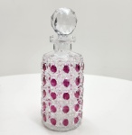 Elegante licoreira em cristal bicolor overlay com corpo em cristal transparente recoberto por camada rubi, lapidada à mão em padrões geométricos de facetados circulares que realçam o brilho e a profundidade do vidro. Tampa facetada em cristal incolor, de corte preciso e alto índice de refração. Obra de refinado trabalho artesanal, típica da cristalaria boêmia meados do sec. XX. Dimensões:30x12 centímetros. Estado: Apresenta bicados no bocal.