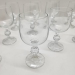 Conjunto composto por 12 taças para vinho branco em cristal transparente, todas com corpo liso e haste ornamentada por esfera facetada, detalhe clássico de lapidação decorativa. Base com leve facetamento radial, produzindo discreto brilho sob a luz. Dimensões:15x7centímetros.